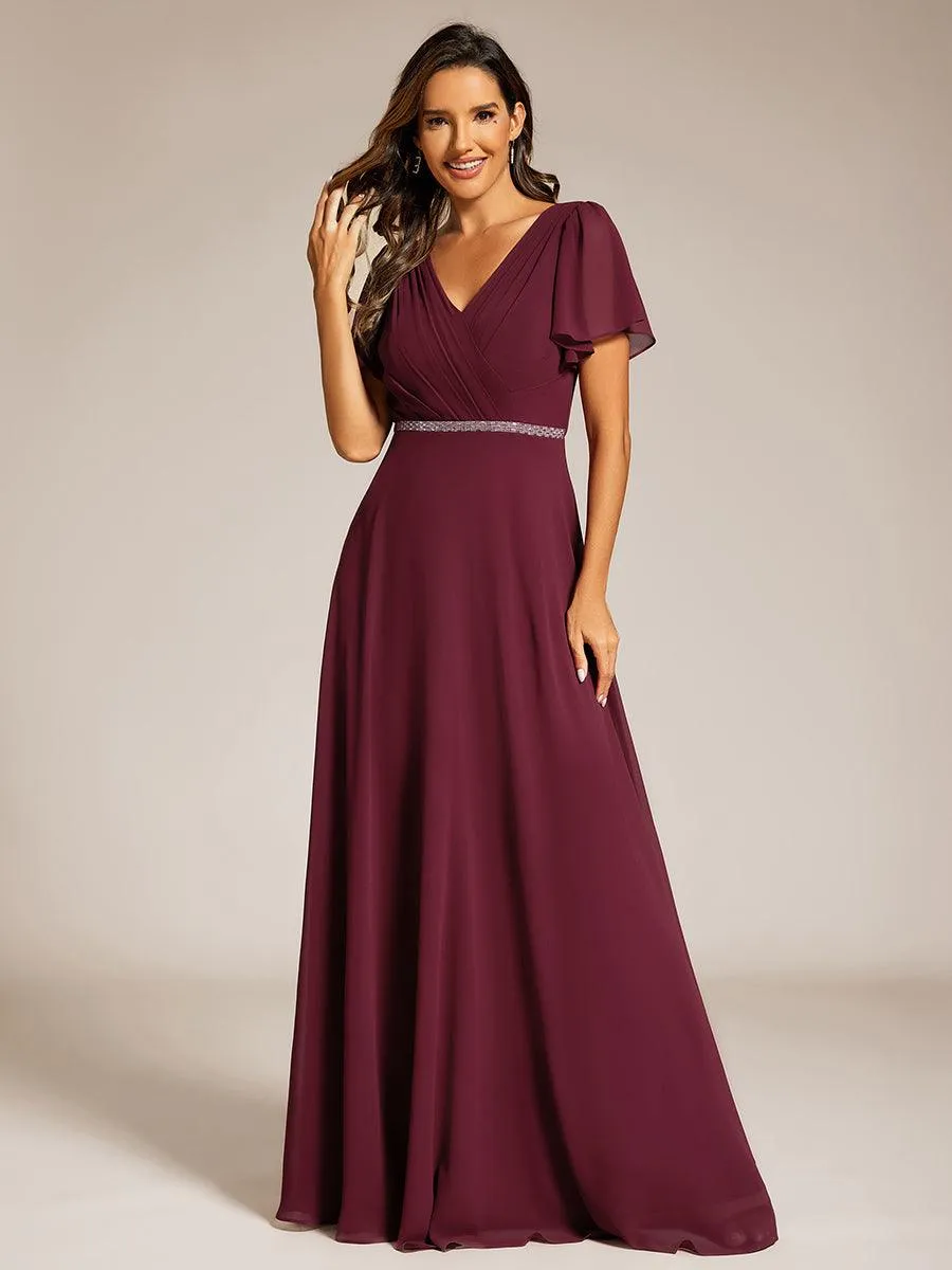 Robe de soirée plissée trapèze en mousseline de soie manches courtes et taille à sequins